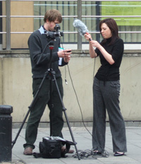 two trainees set up a Sony A1 and gun mic for a vox pop