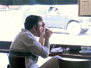 man in coffee shop with bright window