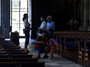 people standing in front of bright window in a cathedral.